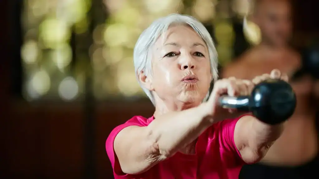 Older woman doing weight training Bicester to help her strength and longevity 