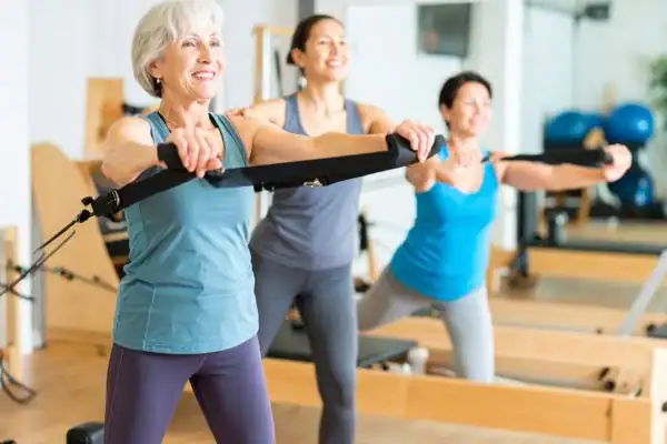 Toning Arms After 60: Empowering Womens Fitness Through Effective Weight Training 2 older woman doing weight training Bicester and resistance in the gym to tone upper arms