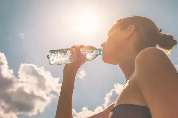 Hydration: The Secret Ingredient for a Toned Stomach and Enhanced Fitness 3 Image of woman drinking water to hydrate Bicester after run.